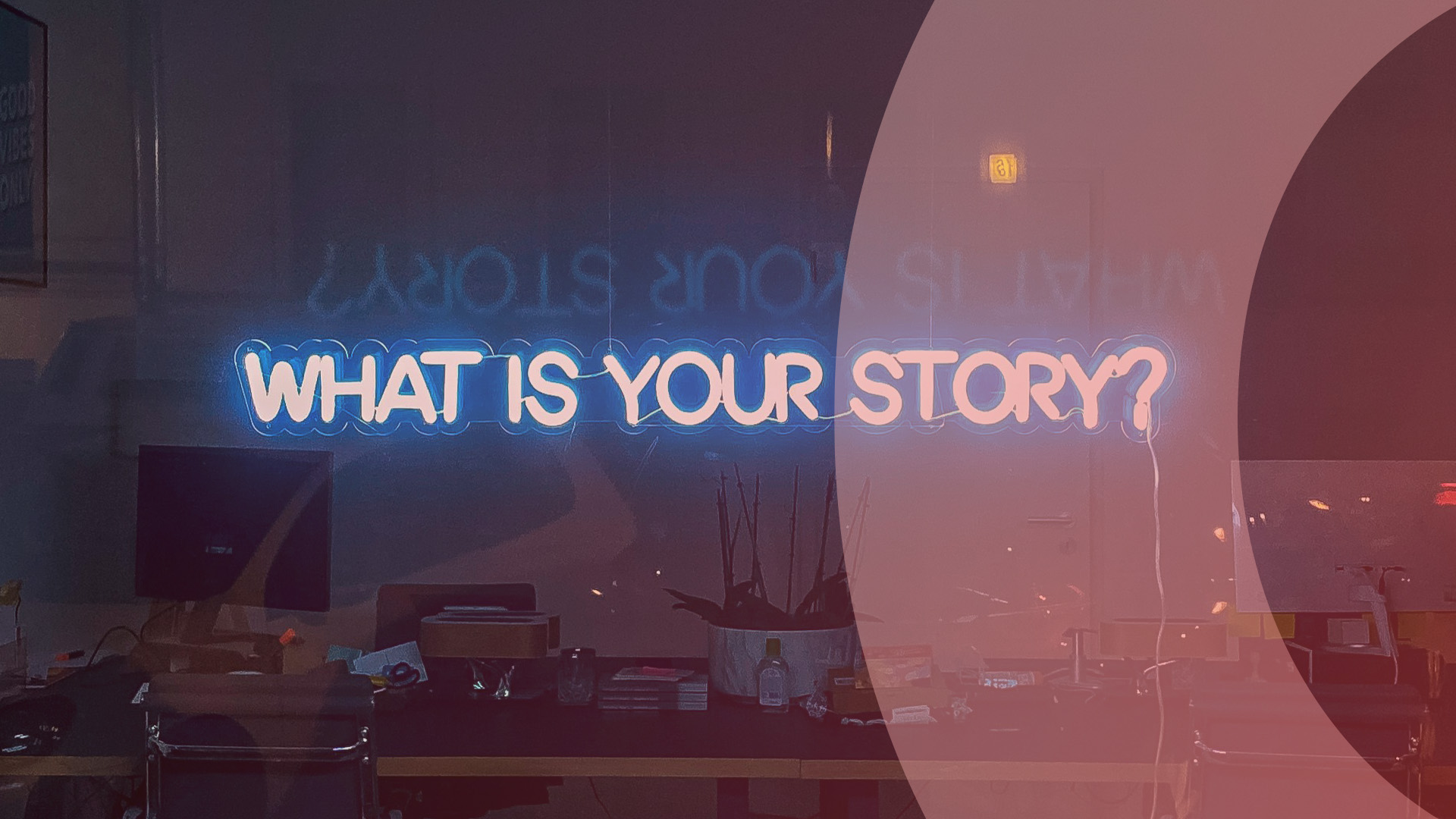 En neonskylt med texten "What is your story?" i ett fönster till ett kontor.