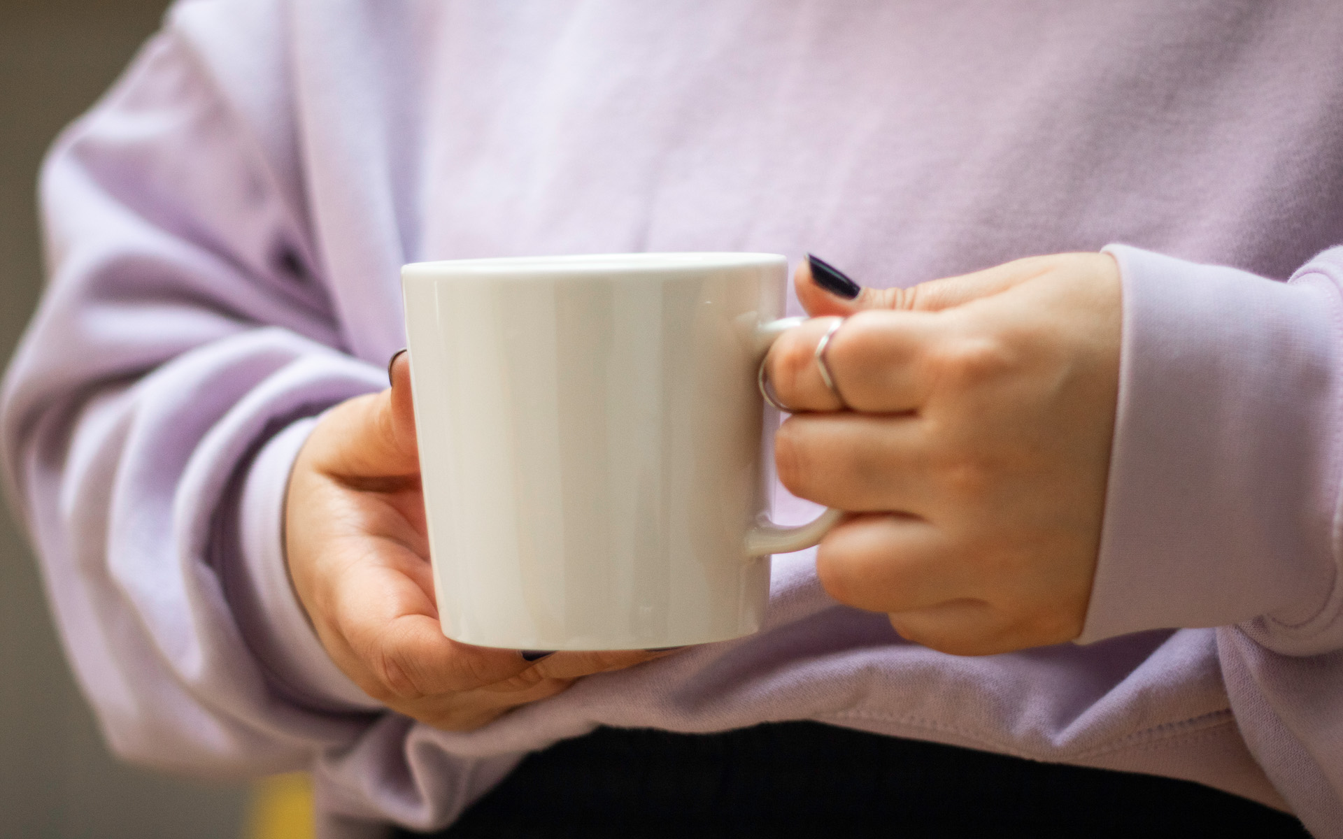 Hand som håller i en kaffekopp.