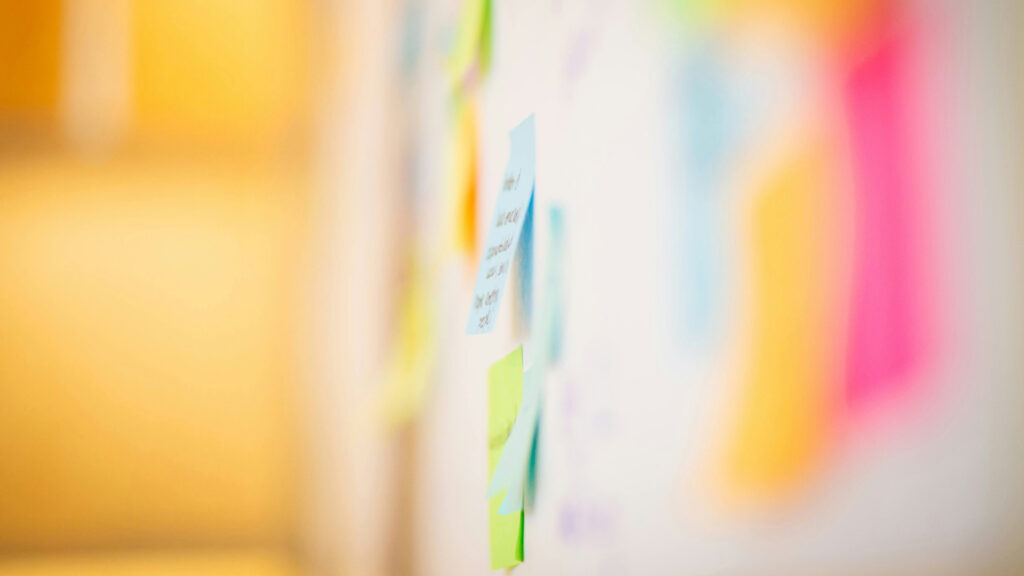Postit-lappar under ett arbetsmöte om utformningen av en digital brief.