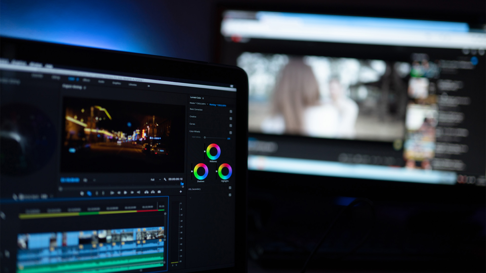 Videoredigeringsverktyg i en laptop och på en större datorskärm i bakgrunden syns YouTubes gränssnitt
