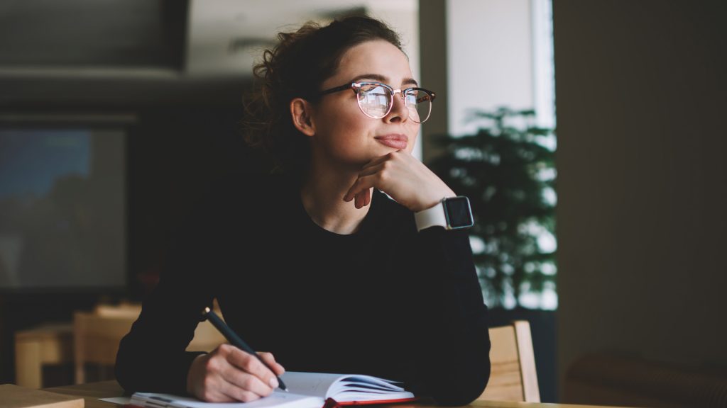 Person som sitter vid ett skrivbord och funderar på olika val.