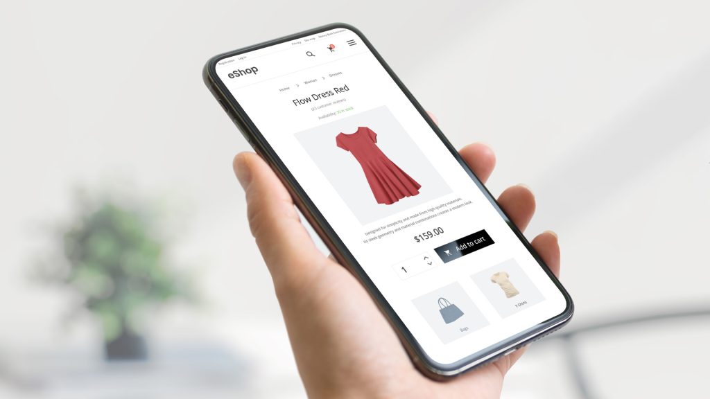 Hand som håller upp en mobil som visar en e-handelssida.
