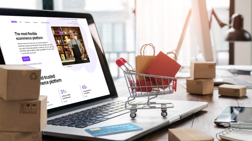 En laptop på skrivbord - ett slags bildkollage med fysisk kundvagn och kartonger.